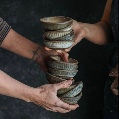 Two people passing handfuls a variety of Progress Ramekins