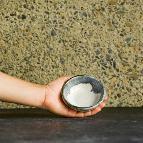 Holding an Inkblot Ramekin against a natural stone wall