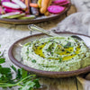 Close up photo of a creamy green sauce in a Progress Dessert Bowl on a rustic wooden table.