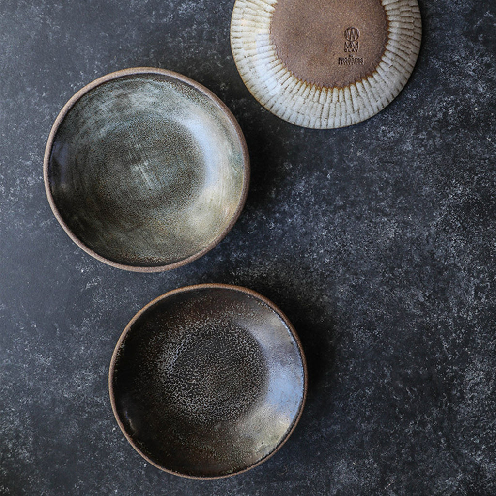 Three Progress Dessert Bowls photographed from overhead. Two bowls display an interior glaze of Eelskin and the bottom of one bowl glazed with White Chamois