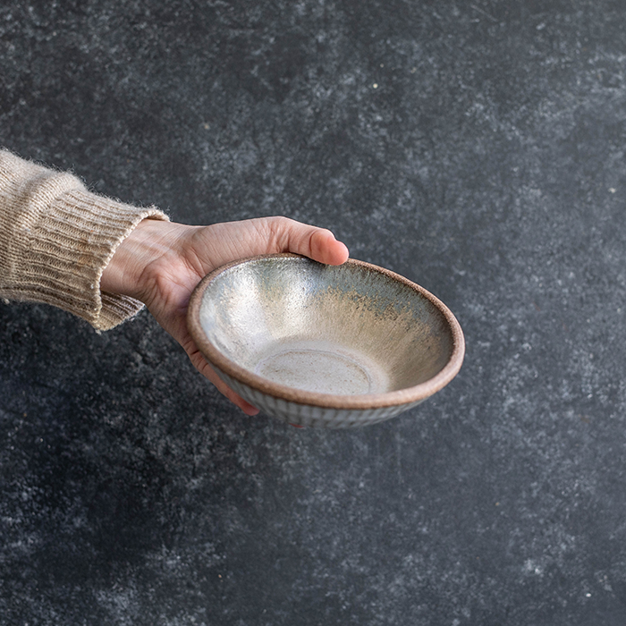 Hand displaying a Progress Small Soup Bowl glazed in Moonshadow. 