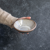 Hand displaying a Progress Small Soup Bowl with White Chamois glaze